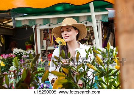 Stock Photography - Young female tourist smelling flowers on market stall, Split, Dalmatia, Croatia. Fotosearch