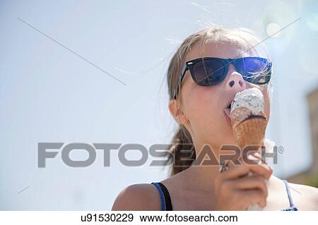 Young girl eating ice cream View Large Photo Image Stock Photo - Young girl eating ice cream. Fotosearch