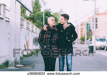 Young lesbian couple strolling along city street View Large Photo Image Stock Image - Young lesbian couple strolling along city street. Fotosearch