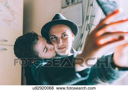 Young lesbian couple taking smartphone selfie in kitchen View Large Photo Image Stock Photo - Young lesbian couple taking smartphone selfie in kitchen. Fotosearch