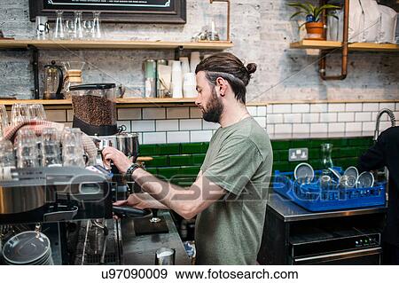 Young male barista preparing coffee in cafe kitchen View Large Photo Image Stock Photo - Young male barista preparing coffee in cafe kitchen. Fotosearch
