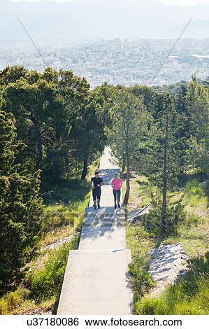 Stock Photograph - Young man and woman running in park, Split, Dalmatia, Croatia. Fotosearch