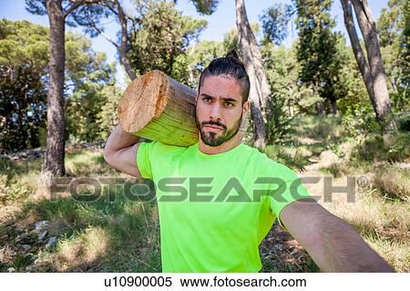 Stock Photography - Young man doing weightlifting training with log in forest, Split, Dalmatia, Croatia. Fotosearch