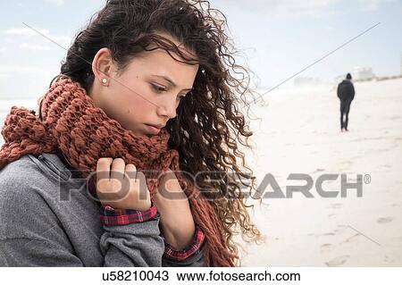 Young man leaving sad young woman wrapped in scarf on beach, Western Cape, South Africa View Large Photo Image Stock Image - Young man leaving sad young woman wrapped in scarf on beach, Western Cape, South Africa. Fotosearch