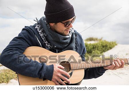 Young man playing acoustic guitar on beach, Western Cape, South Africa View Large Photo Image Stock Photograph - Young man playing acoustic guitar on beach, Western Cape, South Africa. Fotosearch