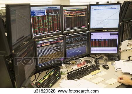 Stock Photo - Young man working on group of computer monitors. Fotosearch