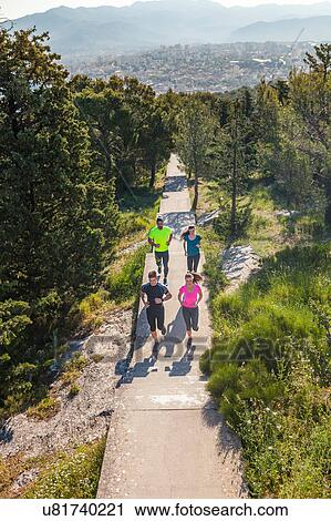 Stock Image - Young men and women running in park, Split, Dalmatia, Croatia. Fotosearch