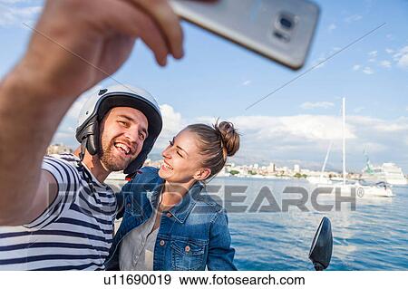 Young moped couple taking selfie on harbour, Split, Dalmatia, Croatia View Large Photo Image Stock Photo - Young moped couple taking selfie on harbour, Split, Dalmatia, Croatia. Fotosearch