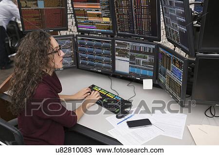 Stock Image - Young trader analyzing computer data. Fotosearch