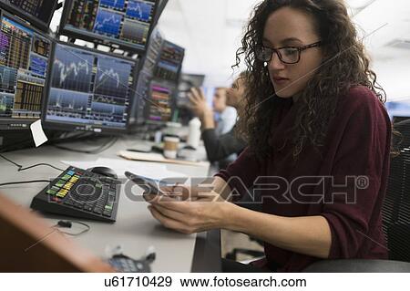 Stock Photo - Young trader using mobile phone. Fotosearch