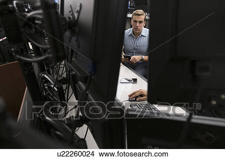Picture - Young traders analyzing computer data. Fotosearch