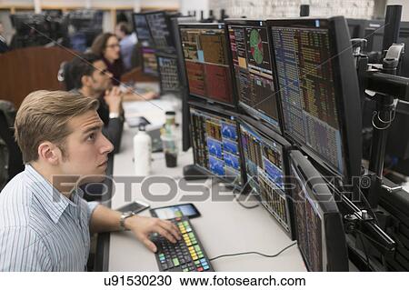 Stock Image - Young traders analyzing computer data. Fotosearch