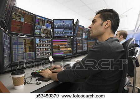 Stock Photo - Young traders analyzing computer data. Fotosearch
