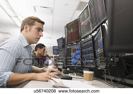 Stock Photo - Young traders analyzing computer data. Fotosearch