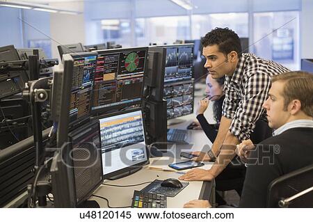 Stock Photography - Young traders analyzing computer data. Fotosearch