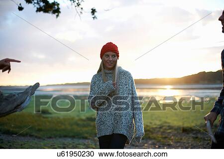 Young woman and male friends collecting sea driftwood at sunset View Large Photo Image Stock Image - Young woman and male friends collecting sea driftwood at sunset. Fotosearch