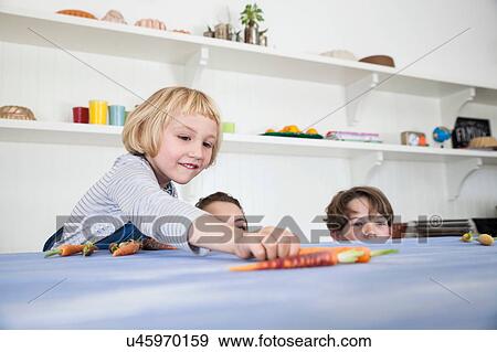 Young woman, boy and girl in kitchen, fooling around, peering over kitchen counter View Large Photo Image Stock Photo - Young woman, boy and girl in kitchen, fooling around, peering over kitchen counter. Fotosearch