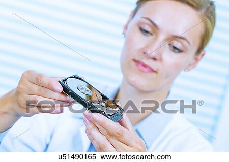 Young woman examining computer hard drive View Large Photo Image Stock Photography - Young woman examining computer hard drive. Fotosearch