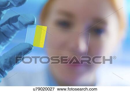 Stock Photo - Young woman holding microscope slide. Fotosearch