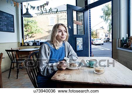Young woman in cafe, eating muesli View Large Photo Image Stock Photograph - Young woman in cafe, eating muesli. Fotosearch