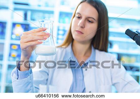 Stock Photograph - Young woman in food quality control laboratory. Fotosearch