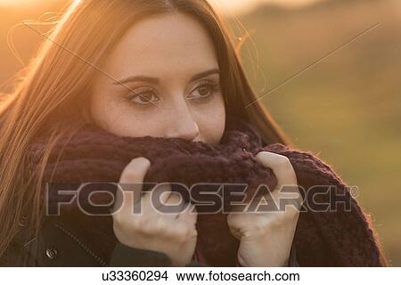 Young woman in rural setting, wearing knitted scarf View Large Photo Image Picture - Young woman in rural setting, wearing knitted scarf. Fotosearch
