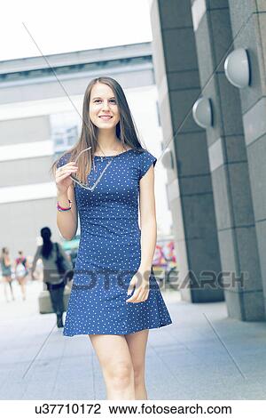 Young woman in short blue dress by buildings View Large Photo Image Stock Image - Young woman in short blue dress by buildings. Fotosearch