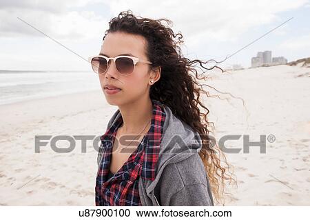 Young woman in sunglasses strolling alone on windy beach, Western Cape, South Africa View Large Photo Image Stock Image - Young woman in sunglasses strolling alone on windy beach, Western Cape, South Africa. Fotosearch