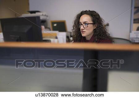 Young woman looking at computer monitor View Large Photo Image Stock Photo - Young woman looking at computer monitor. Fotosearch