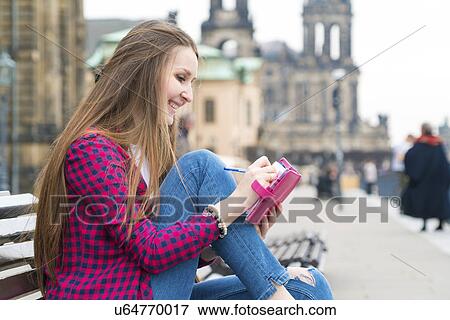 Young woman making notes in notebook View Large Photo Image Stock Photo - Young woman making notes in notebook. Fotosearch