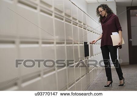 Young woman opening drawer in corridor View Large Photo Image Stock Photo - Young woman opening drawer in corridor. Fotosearch