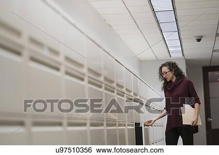 Young woman opening drawer in corridor View Large Photo Image Stock Photograph - Young woman opening drawer in corridor. Fotosearch
