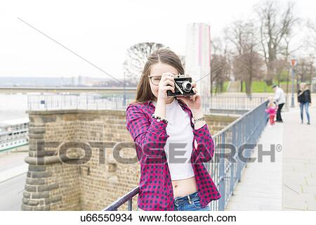 Young woman taking photo with camera View Large Photo Image Picture - Young woman taking photo with camera. Fotosearch
