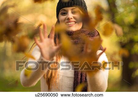 Young woman throwing autumn leaves in air, smiling View Large Photo Image Stock Image - Young woman throwing autumn leaves in air, smiling. Fotosearch