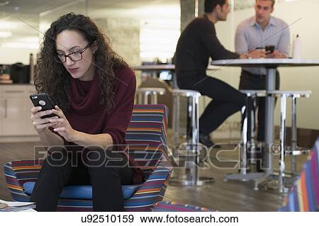 Young woman using mobile phone in common area View Large Photo Image Stock Photo - Young woman using mobile phone in common area. Fotosearch