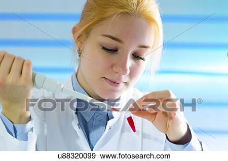 Young woman using pipette View Large Photo Image Stock Photo - Young woman using pipette. Fotosearch