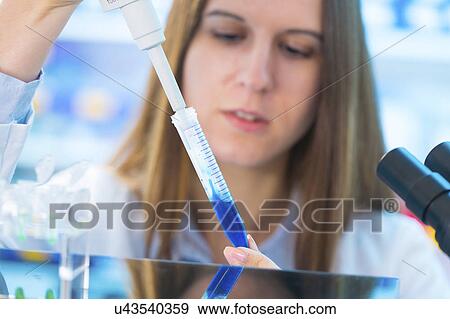 Young woman using pipette with blue liquid View Large Photo Image Stock Photo - Young woman using pipette with blue liquid. Fotosearch