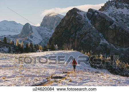 Picture - Young woman walking across landscape, Limides Lake, South Tyrol, Dolomite Alps, Italy. Fotosearch