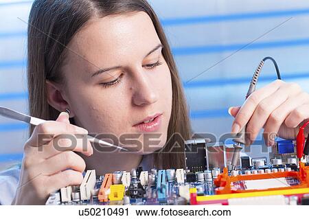 Young woman working on circuit board View Large Photo Image Stock Image - Young woman working on circuit board. Fotosearch