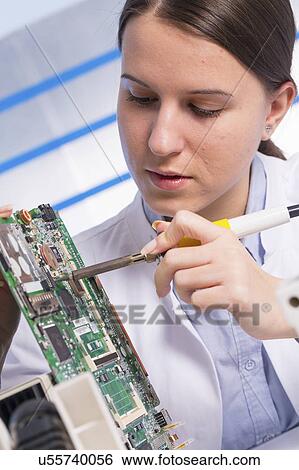 Young woman working on circuit board View Large Photo Image Stock Photograph - Young woman working on circuit board. Fotosearch