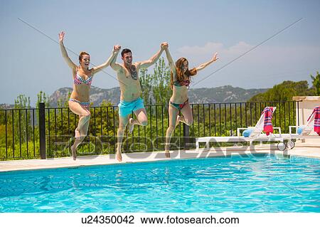Young women and man jumping together into boutique hotel swimming pool, Majorca, Spain View Large Photo Image Stock Image - Young women and man jumping together into boutique hotel swimming pool, Majorca, Spain. Fotosearch