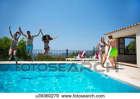 Young women and man jumping together into boutique hotel swimming pool, Majorca, Spain View Large Photo Image Stock Photo - Young women and man jumping together into boutique hotel swimming pool, Majorca, Spain. Fotosearch