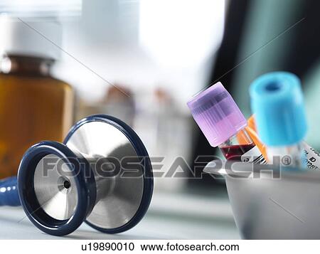 Stock Image - Close-up of blood samples and a stethoscope on a doctor's desk.. Fotosearch