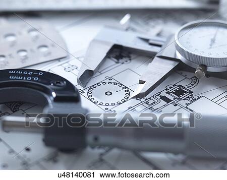 Stock Image - Drawing and measuring equipment on an engineering blue print.. Fotosearch
