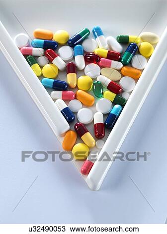 Stock Image - Pills pouring out of measuring triangle.. Fotosearch
