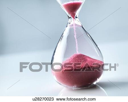 Stock Image - Sand flowing through an hourglass.. Fotosearch
