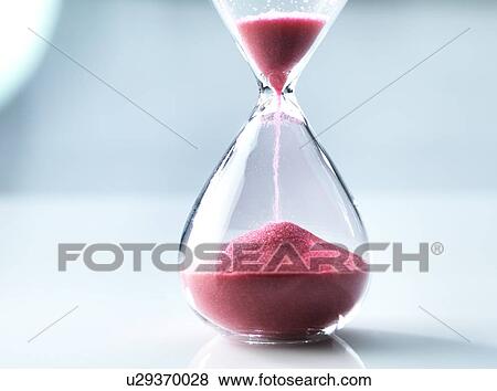 Stock Photo - Sand flowing through an hourglass.. Fotosearch