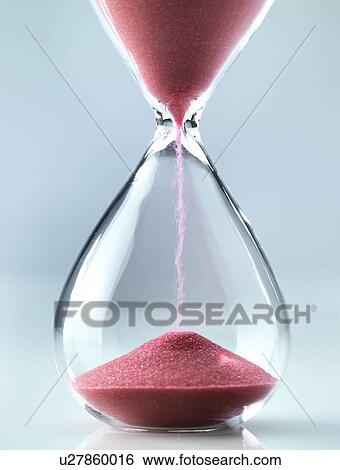 Stock Photograph - Sand flowing through an hourglass.. Fotosearch