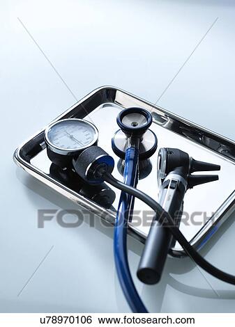 Stock Photograph - Sphygmomanometer, stethoscope and otoscope on a metal tray.. Fotosearch