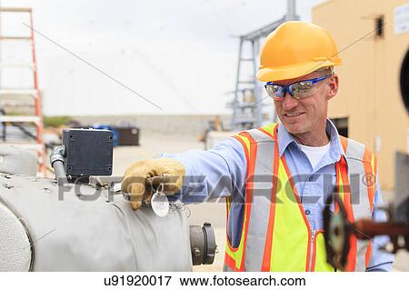 Stock Photo - Electrical engineer examining pressure sensor. Fotosearch